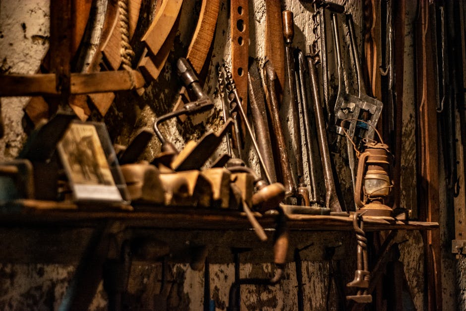 A nostalgic view of an old workshop, showcasing vintage tools and machinery against a timeworn backdrop.